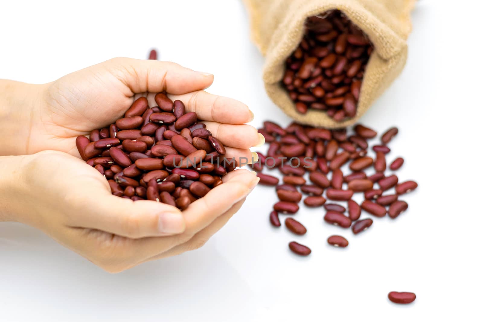 Grains Red beans in hand a sack on a white background