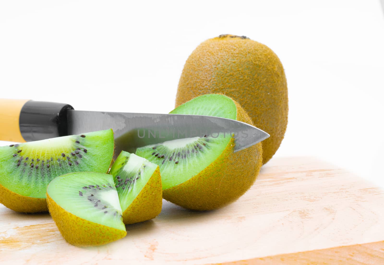 A knife kiwi fruit on a white background