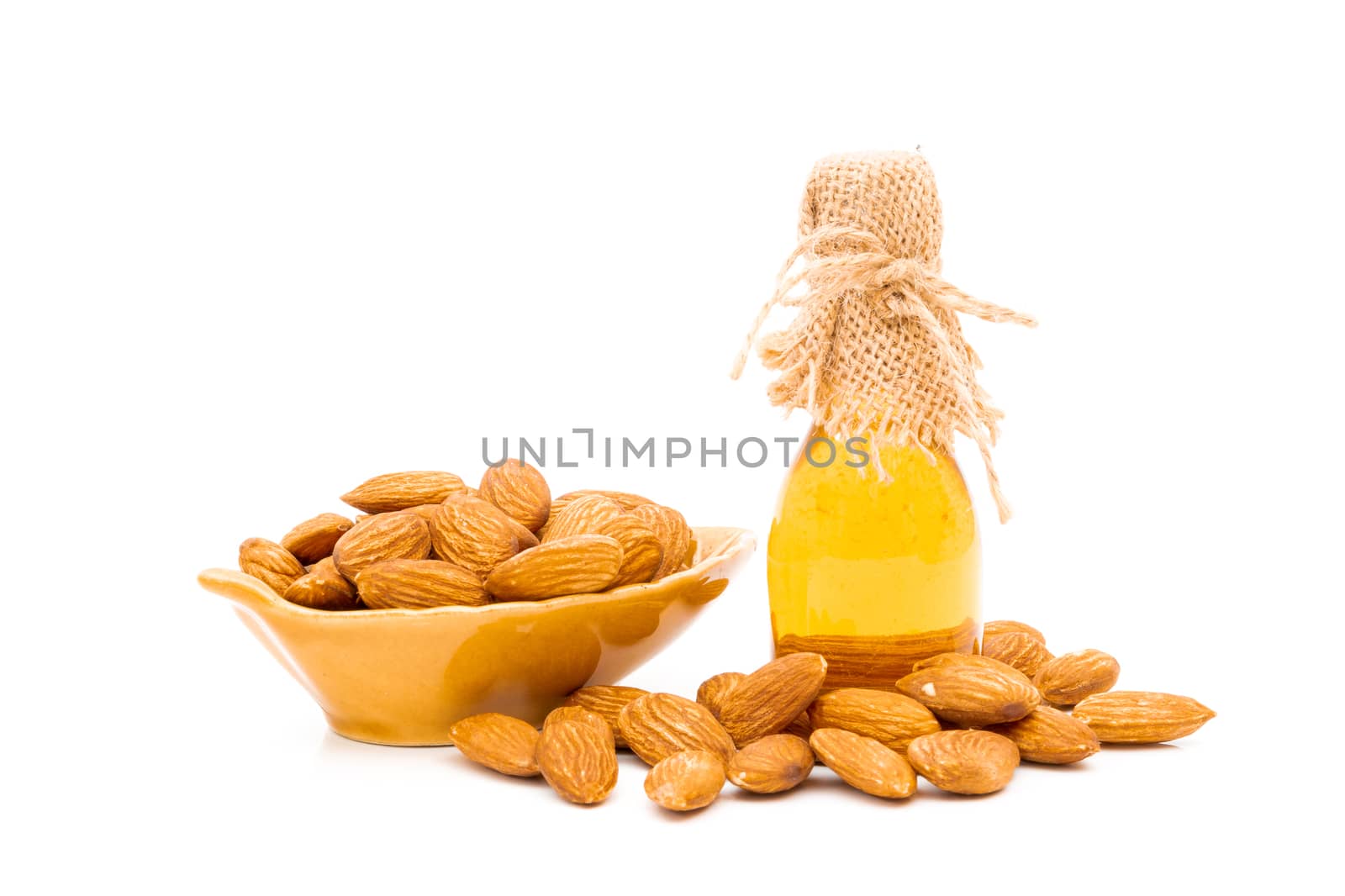 Honey jar and almonds on a white background