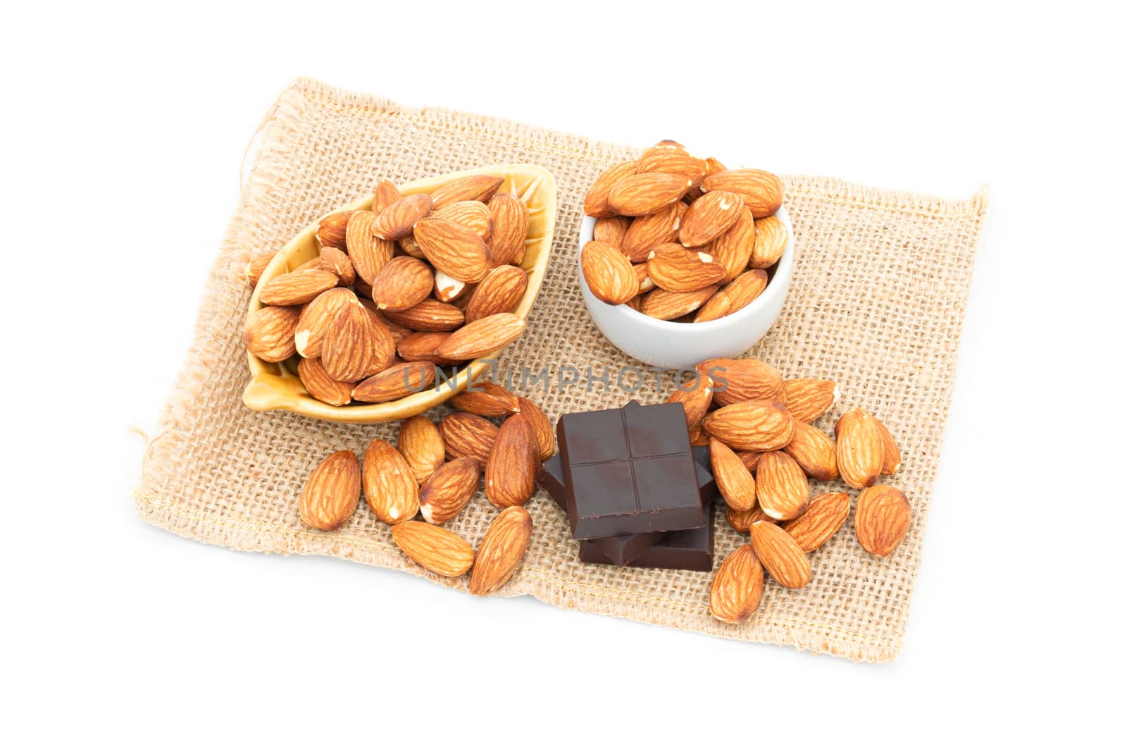 chocolate and almonds on a white background by sompongtom