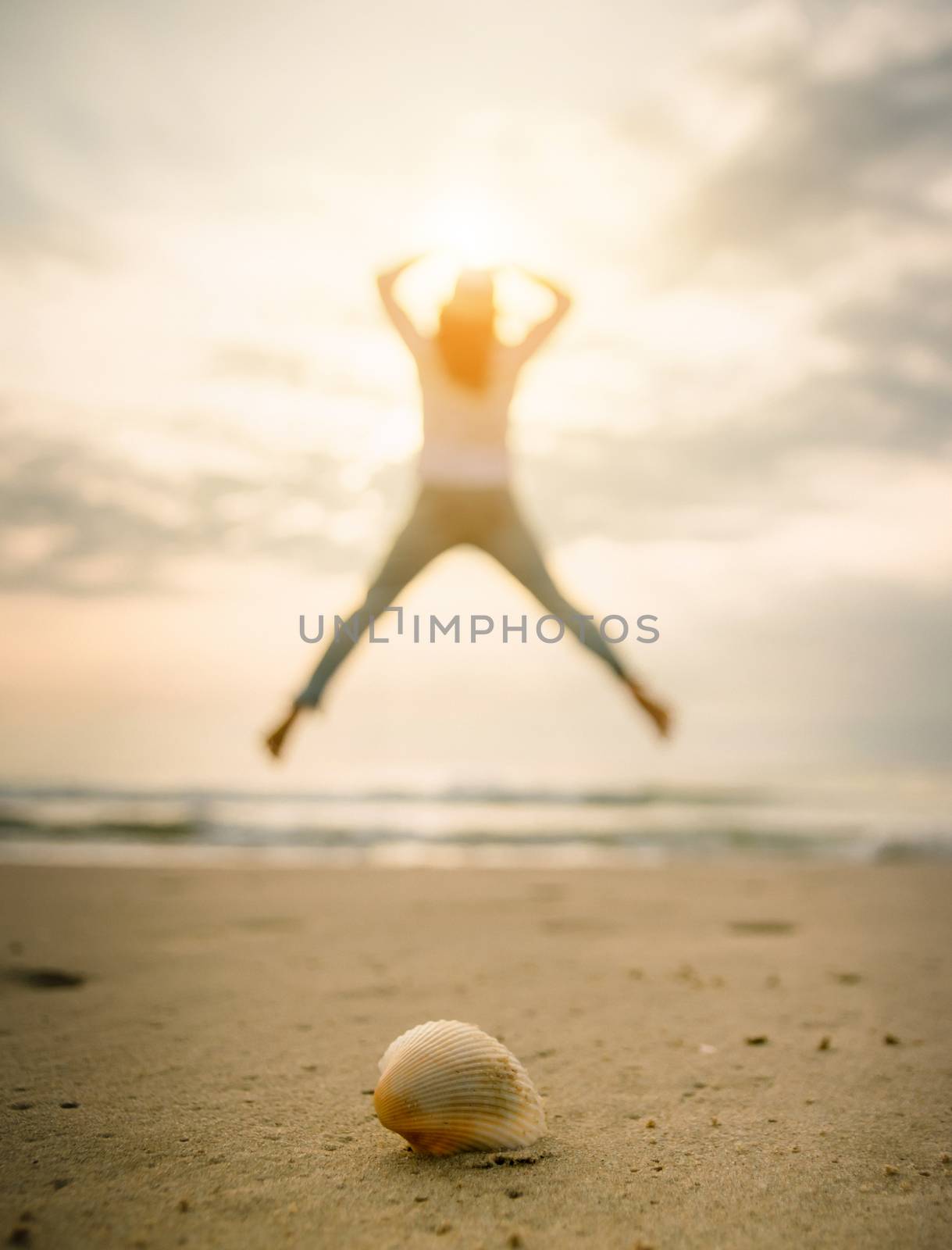 Shells on the beach female jump happy travel holiday by sompongtom