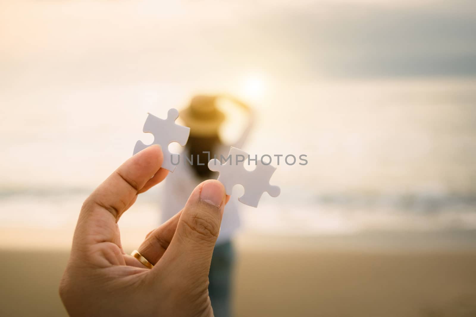 Man's hand in to connect puzzle piece concept love on woman on the back the relationship a couple by sompongtom