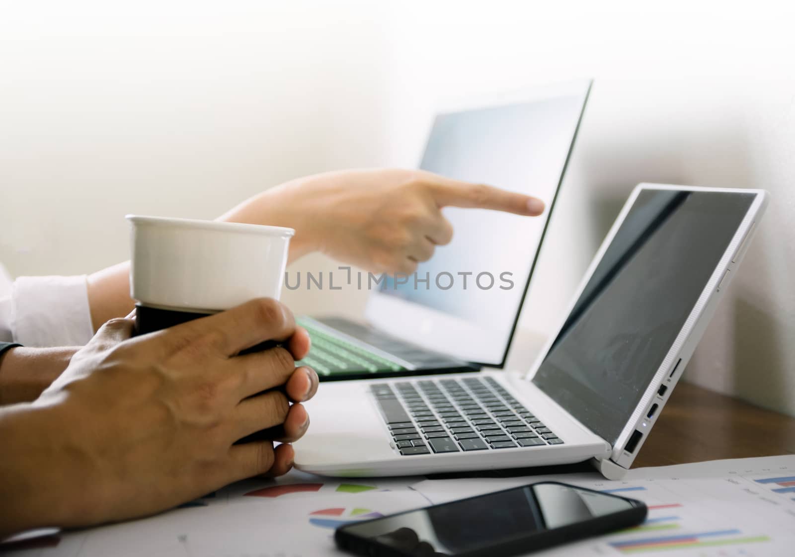 The hand that holds the coffee cup on the desk