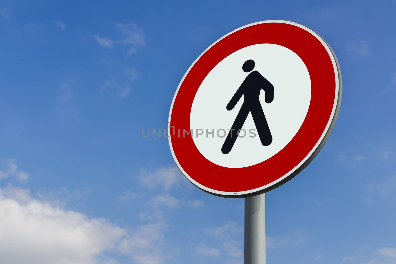 Walking forbidden sign on a blue sky with clouds