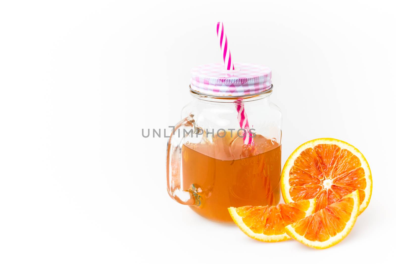 Hot orange tea in mason jar with straw, isolated on white background. Space for text.