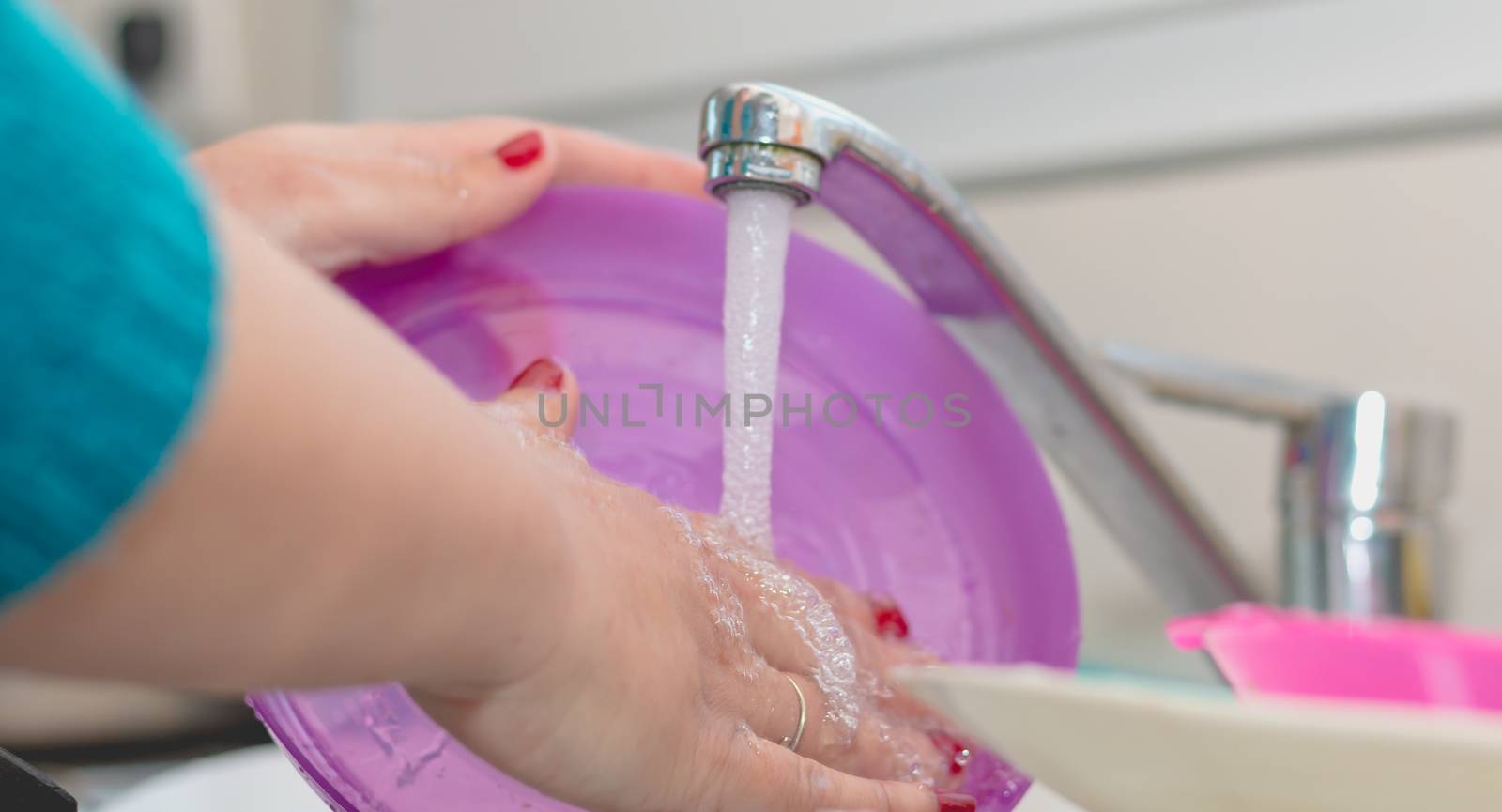 Close-up of the hand of a woman doing dishes