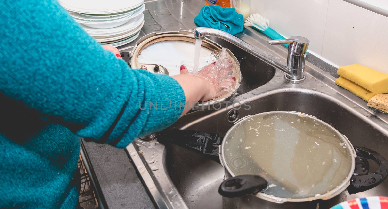 Close-up of the hand of a woman doing dishes