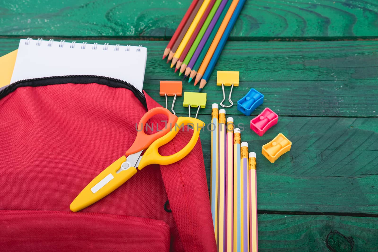 Top view flat lay of red school bag backpack and accessories tools for children education on green wood background, Back to school concept and have copy space for use