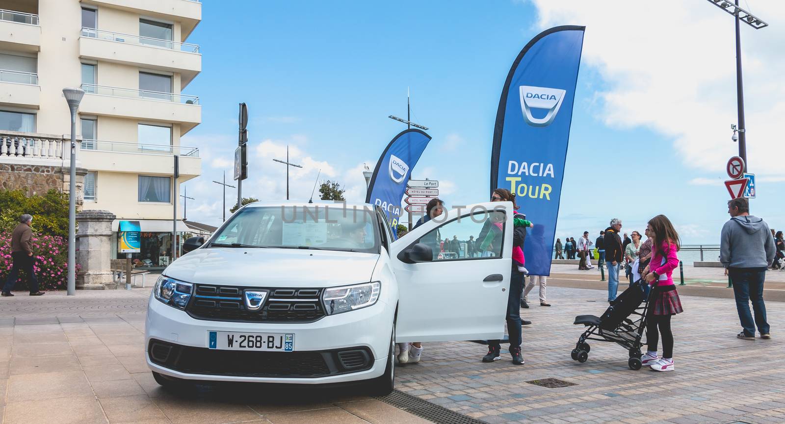 Sables d Olonnes, France - May 07, 2017 : Dacia Tour 2017 is a commercial operation organized by the car builder in order to present its cars throughout France - A young man watching a car