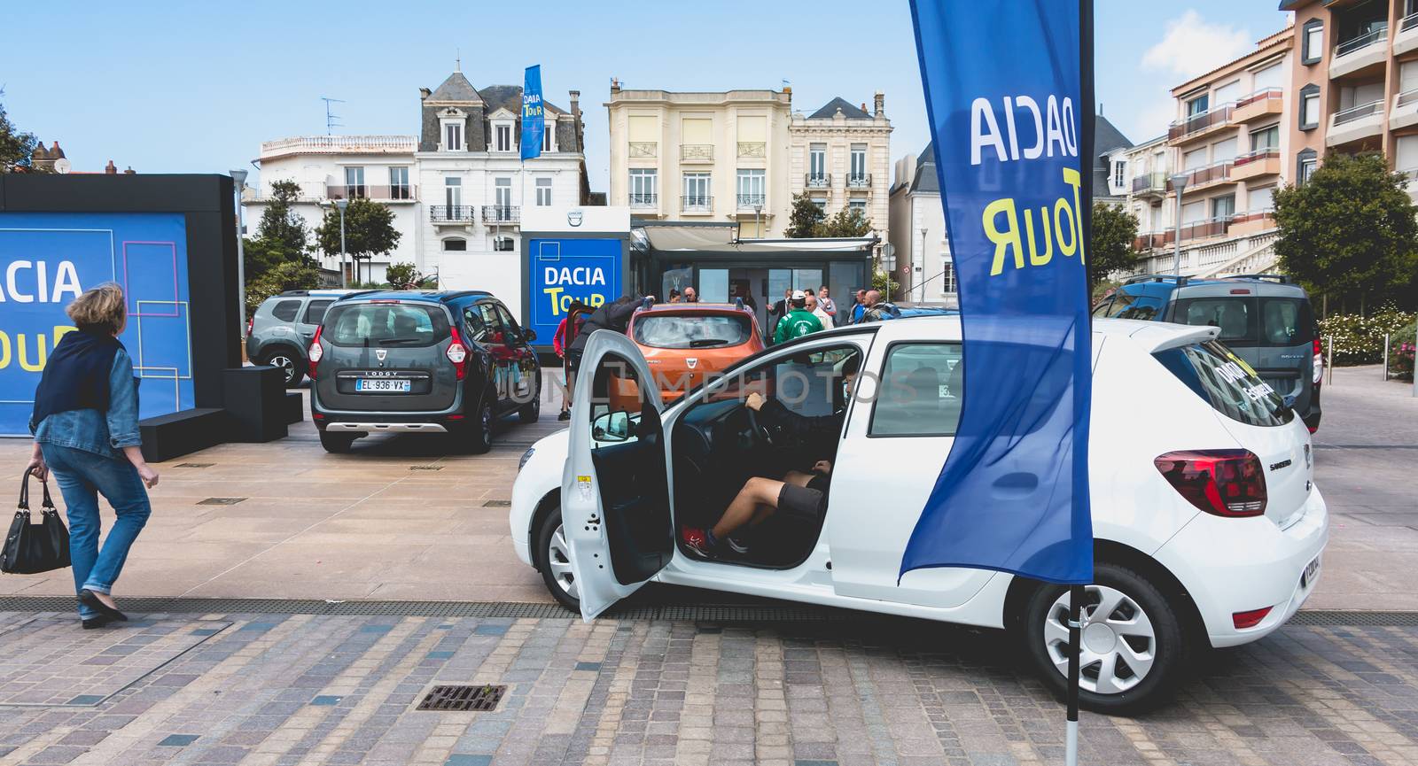 Sables d Olonnes, France - May 07, 2017 : Dacia Tour 2017 is a commercial operation organized by the car builder in order to present its cars throughout France - A young man watching a car