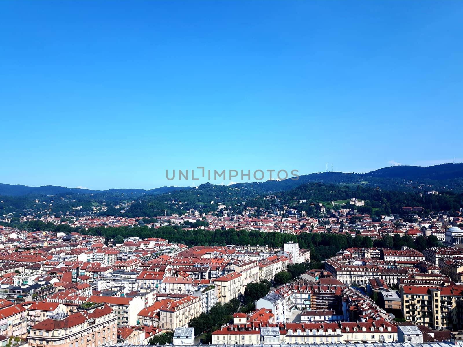 Turin, Italy - 06/06/2020: Beautiful panoramic view from Mole Antoneliana to the city of Turin in summer days with clear blue sky and the alps in the background.