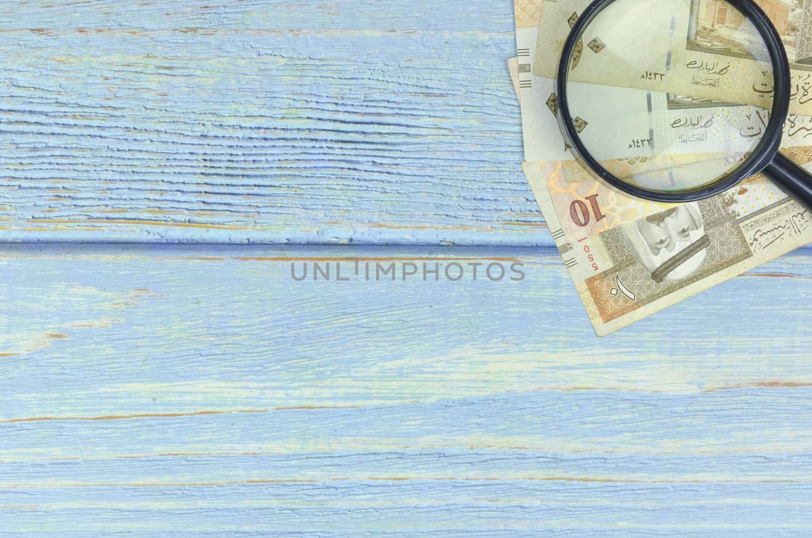 Saudi Arabia money on wooden background.