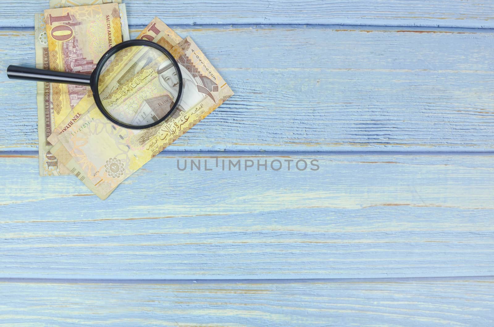 Saudi Arabia money on wooden background.