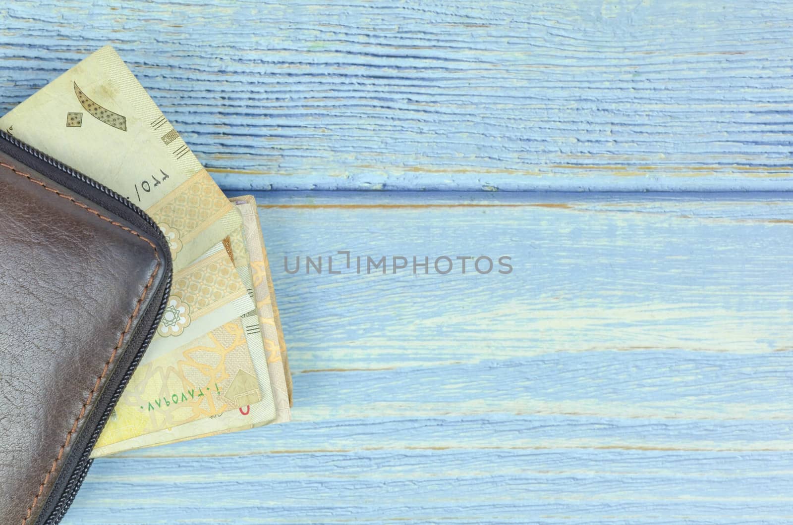 Saudi Arabia money on wooden background.