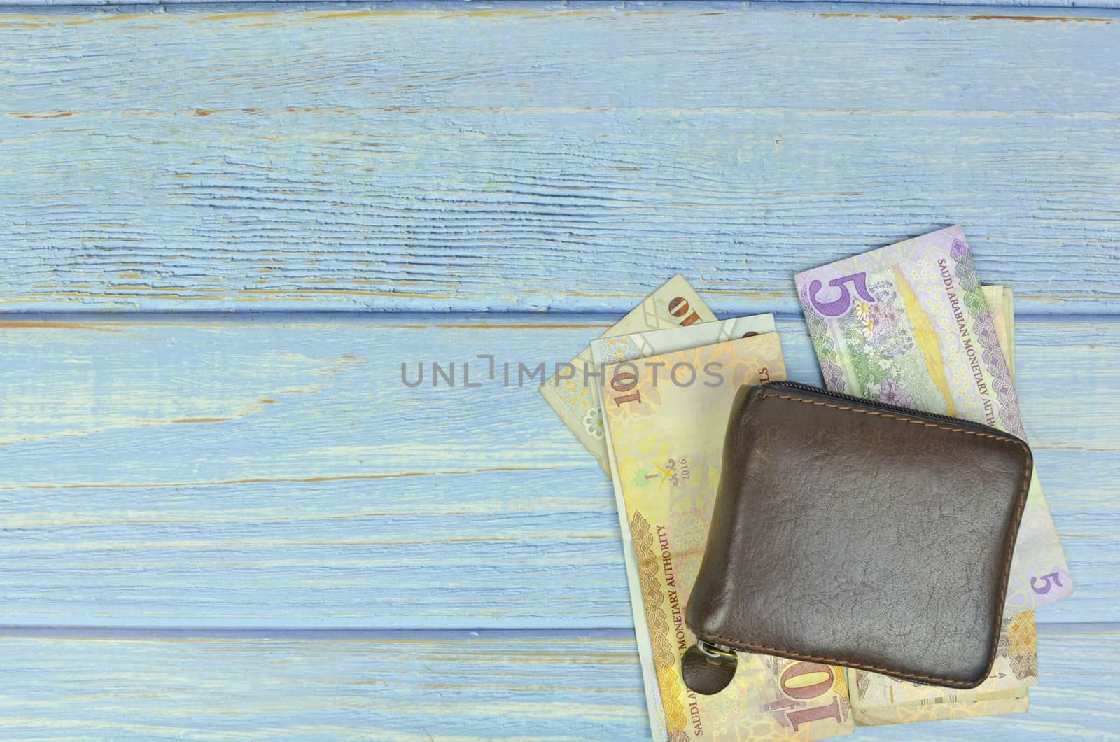 Saudi Arabia money on wooden background.