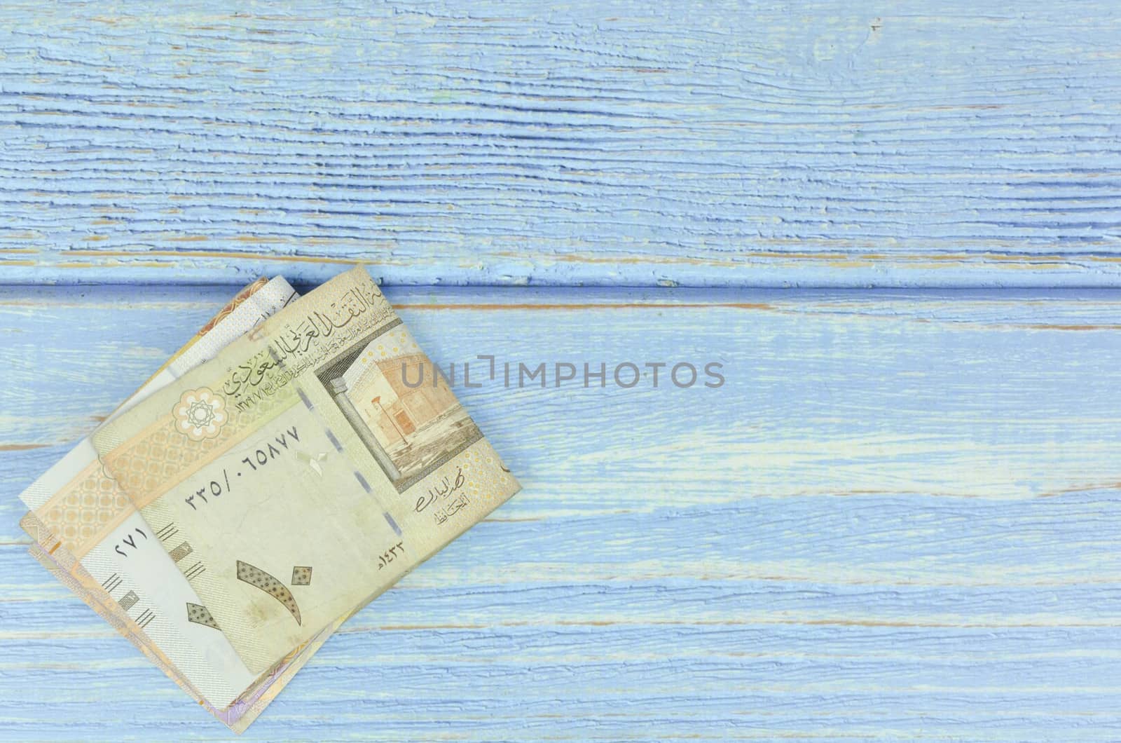 Saudi Arabia money on wooden background.