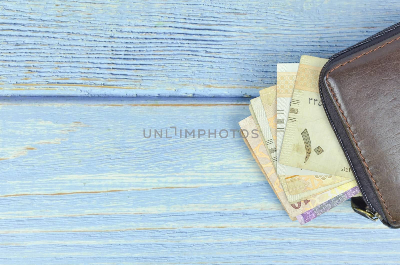 Saudi Arabia money on wooden background.