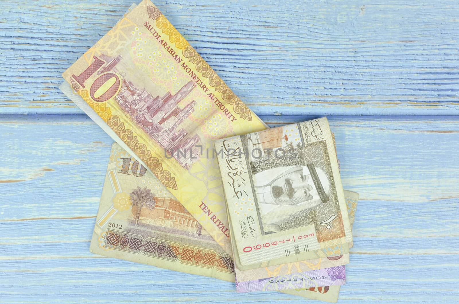 Saudi Arabia money on wooden background.