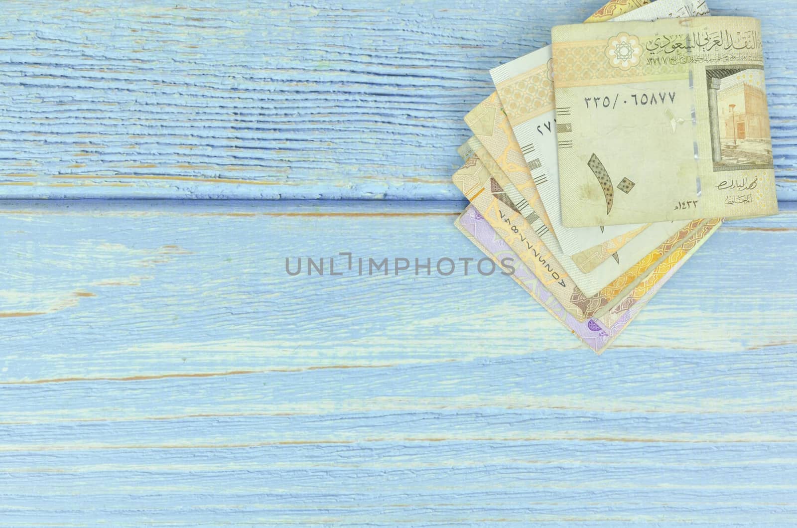 Saudi Arabia money on wooden background.