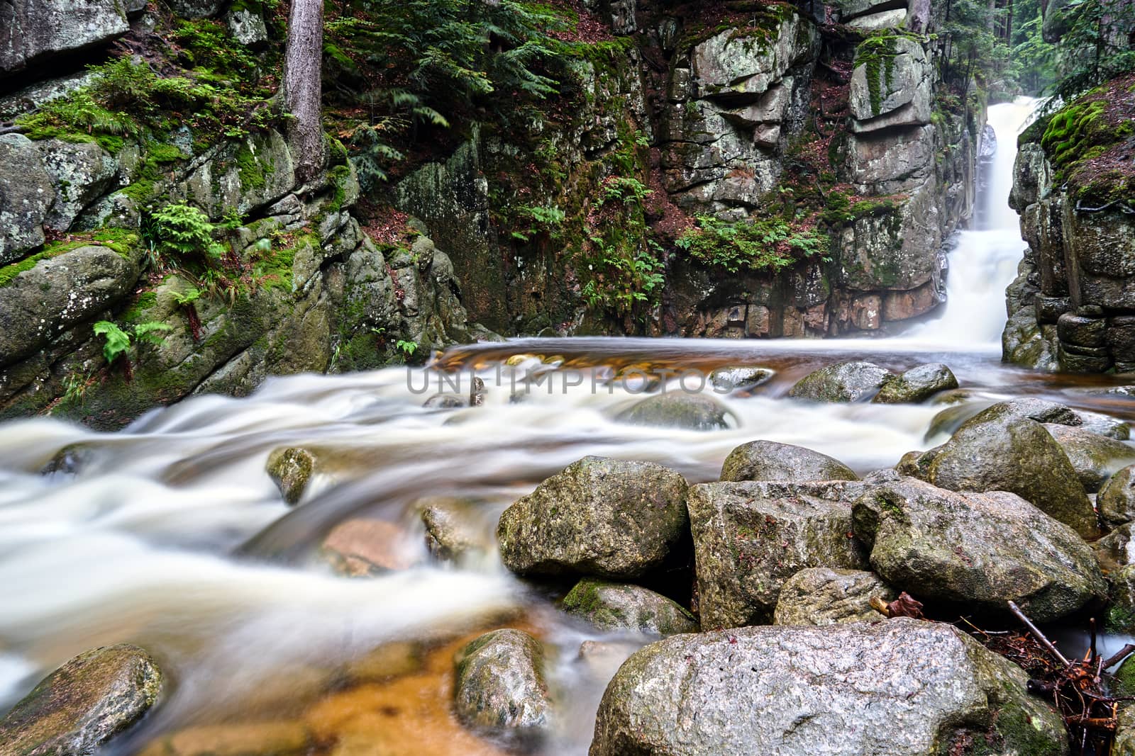 Rocks, boulders and waterfall in the forest in the Giant Mountains in Poland