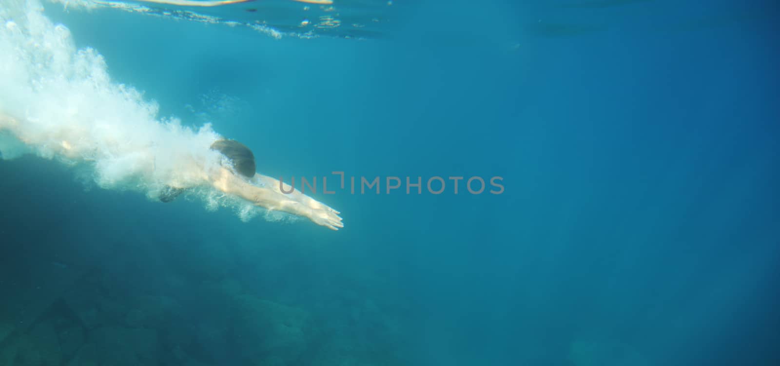 Woman swimming underwater in blue transparent sea water in summer Croatia