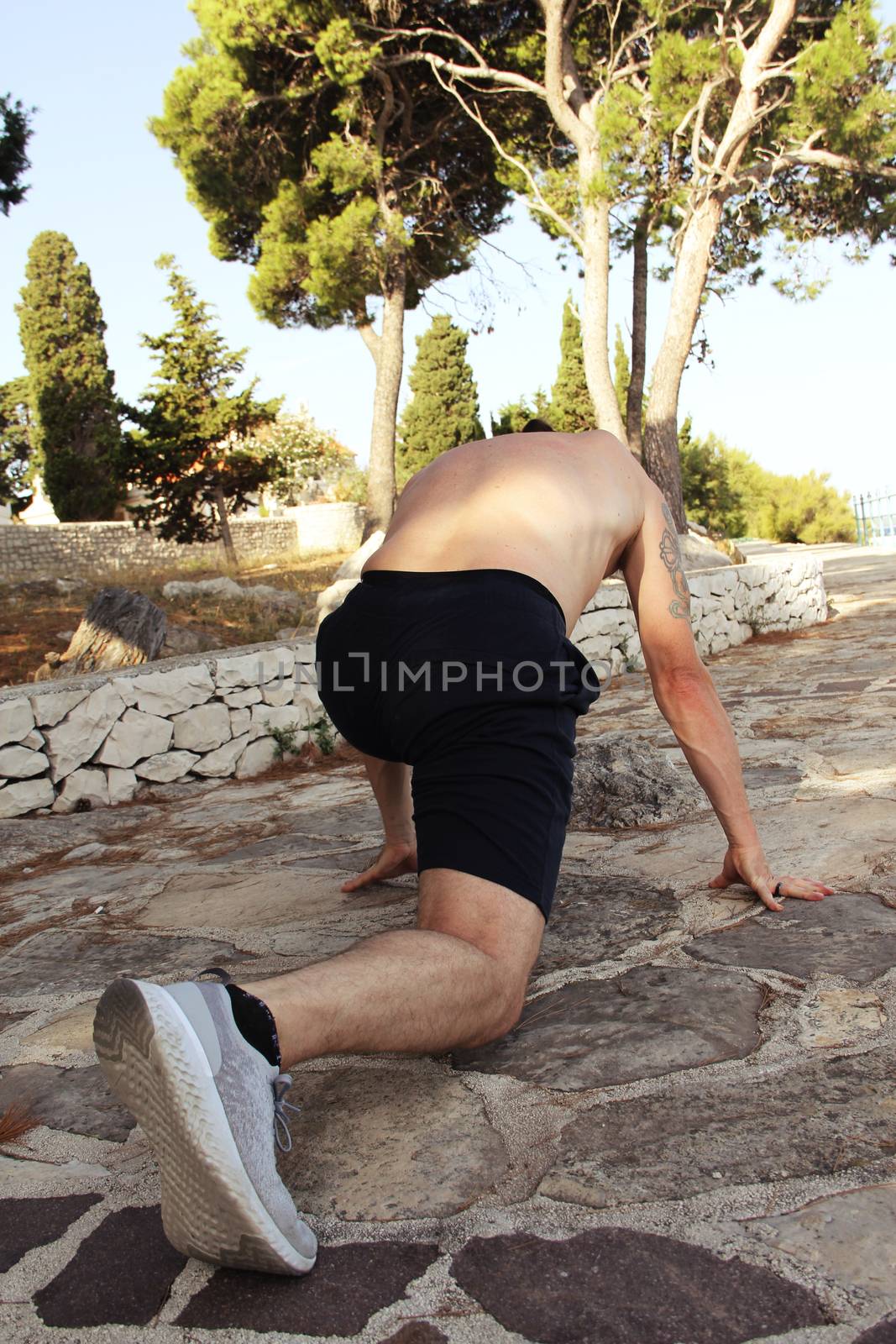Man stretching outdoors by destillat