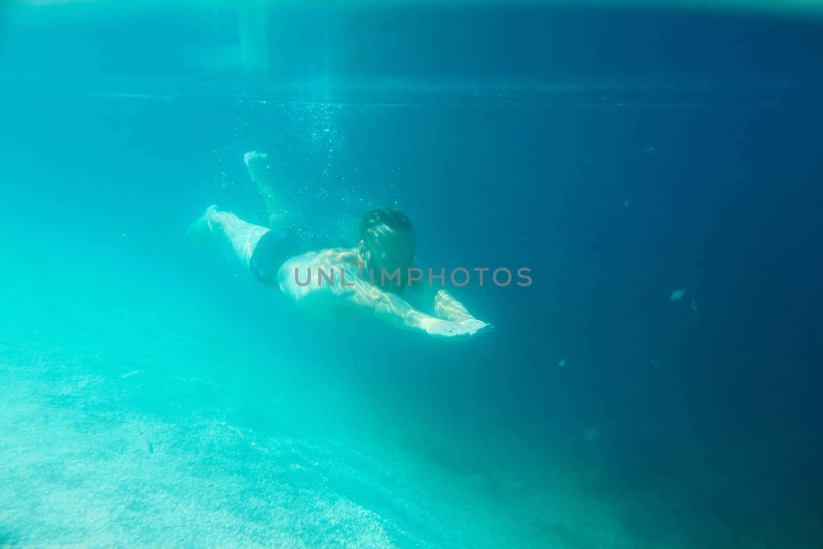 Mid adult bearded long hair man swimming underwater in mediterranean adriatic sea in Croatia