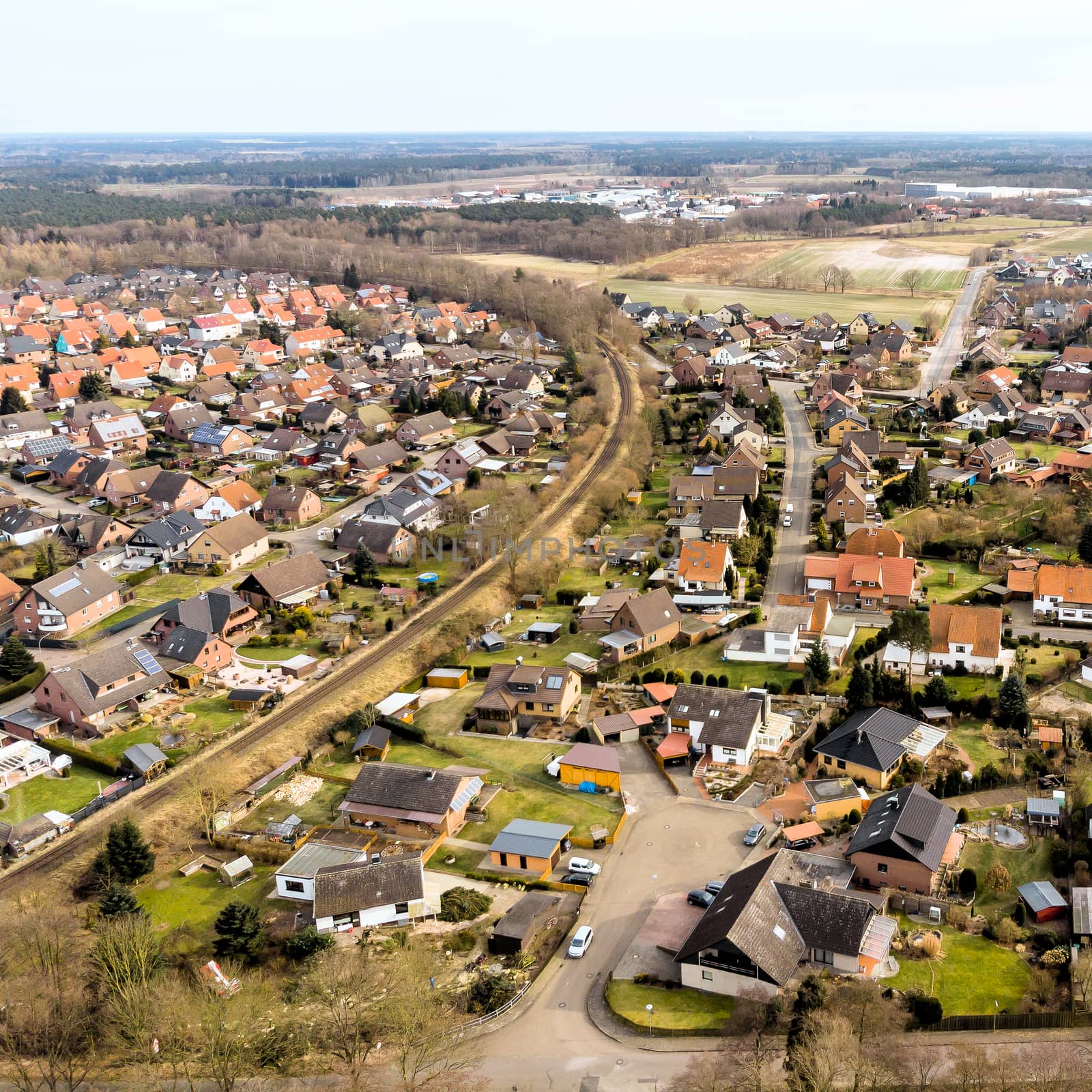 Aerial view of a small village in Lower Saxony, which is cut up by a single-lane railway line. by geogif