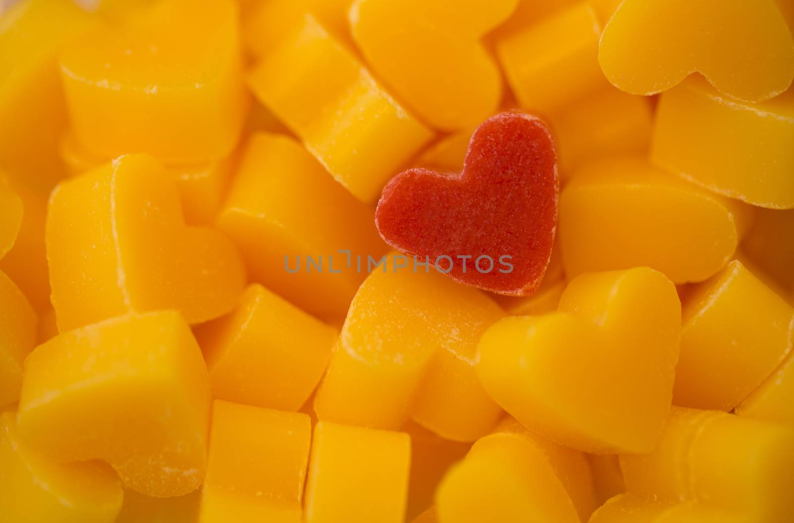 One red heart shaped soap with many yellow heart shaped soaps