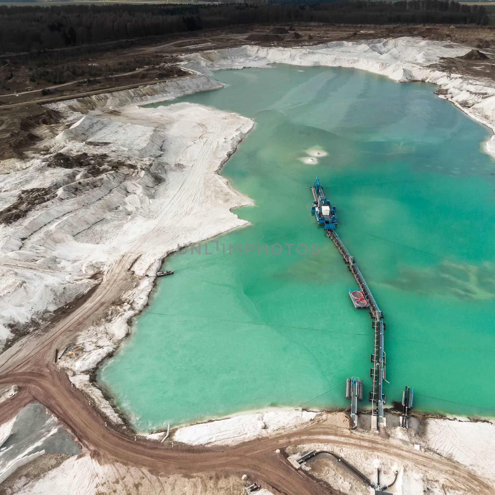 Aerial view of the long boom of a suction excavator in a quartz quarry for the excavation of white sand. by geogif