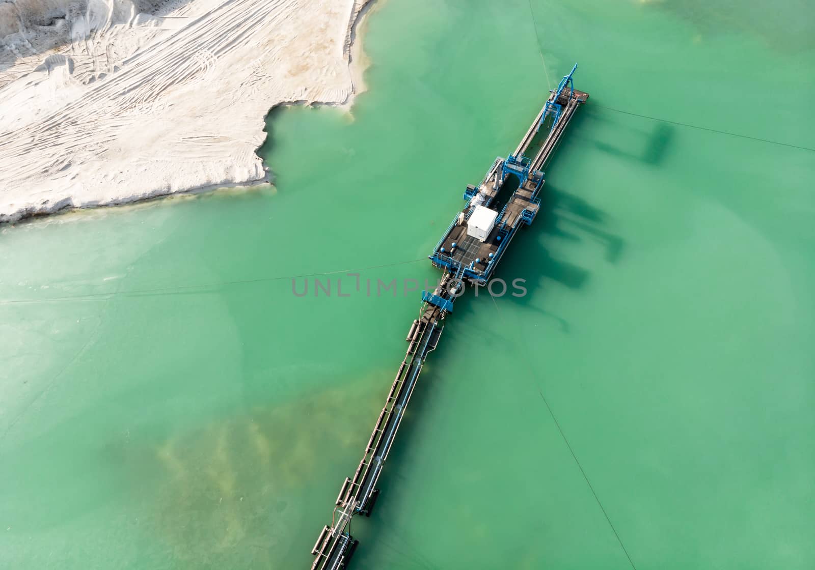 Aerial view of the long boom of a suction excavator in a quartz quarry for the excavation of white sand. by geogif