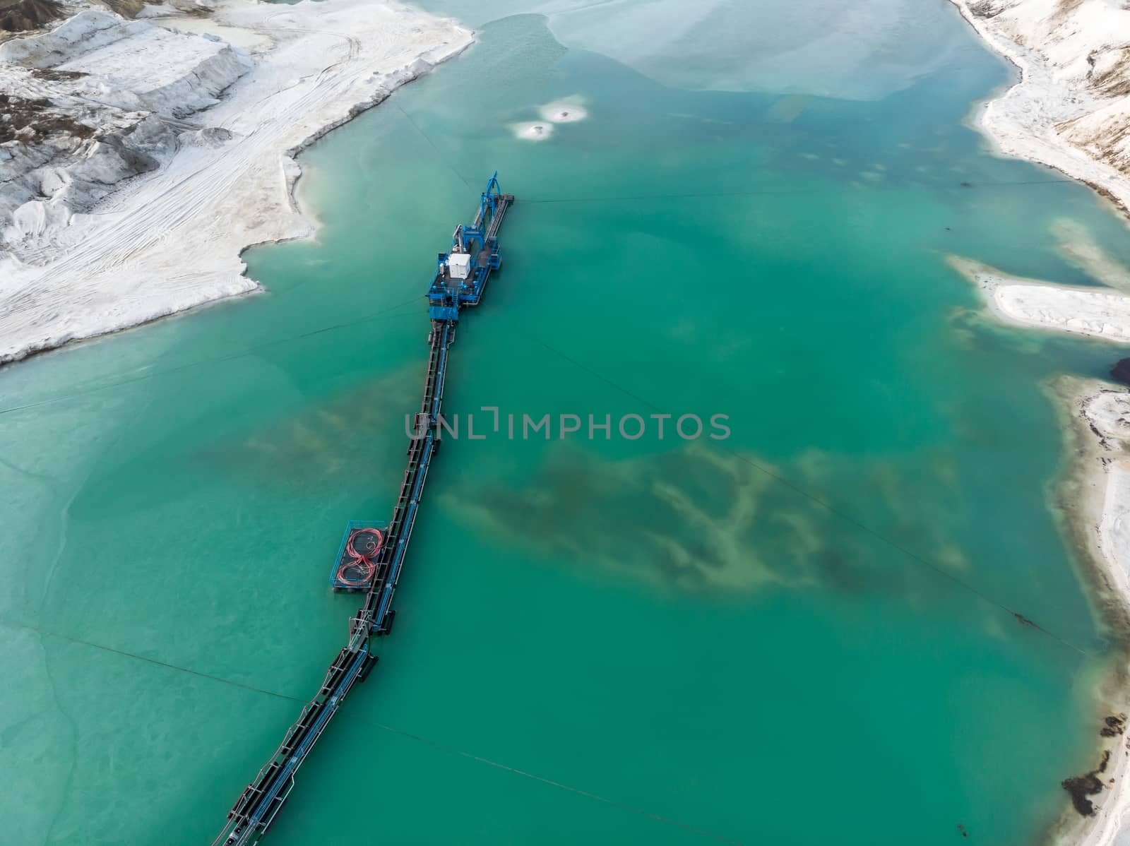 Aerial view of the long boom of a suction excavator in a quartz quarry for the excavation of white sand. by geogif