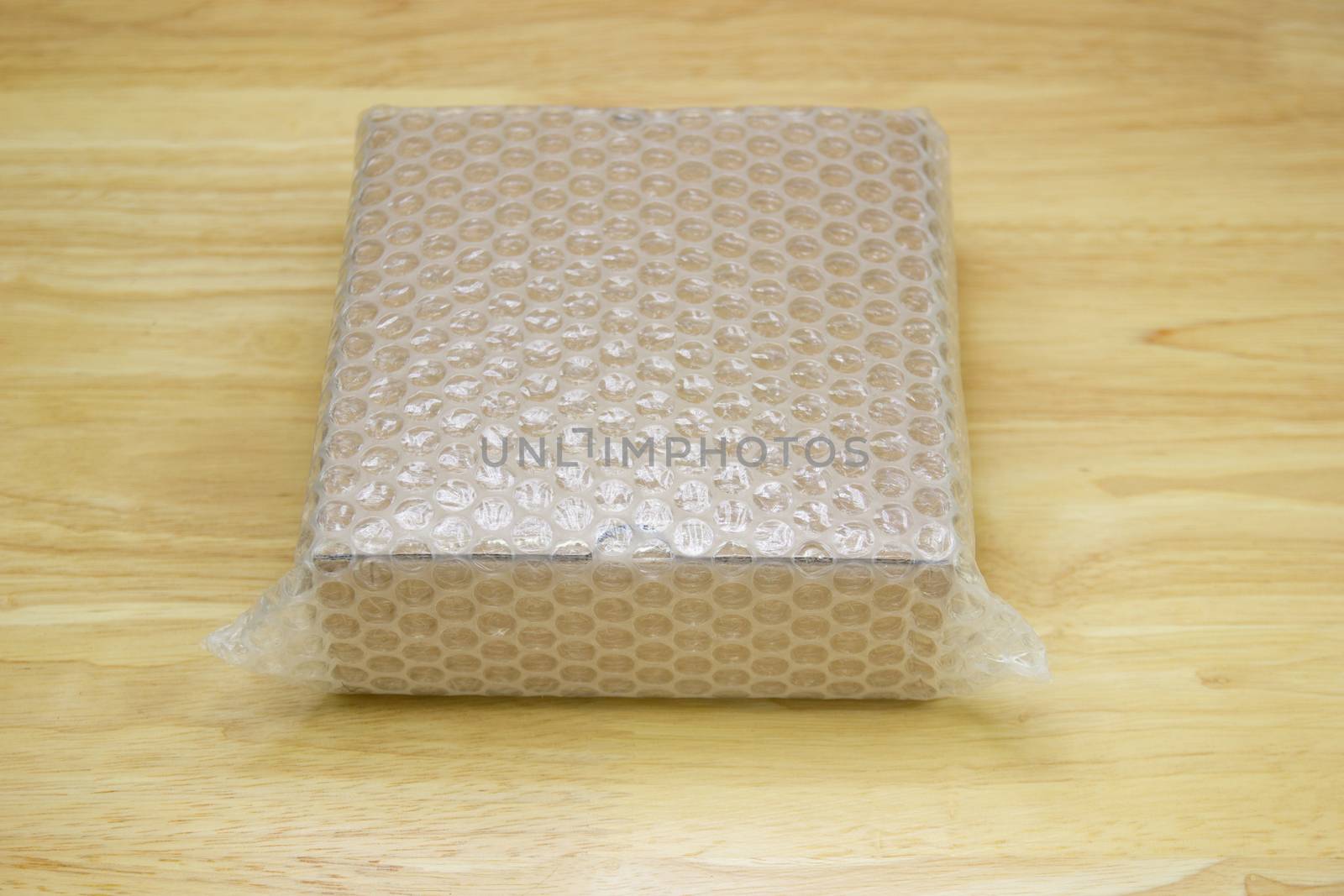 Bubbles covering the box by bubble wrap for protection product cracked on wood table 