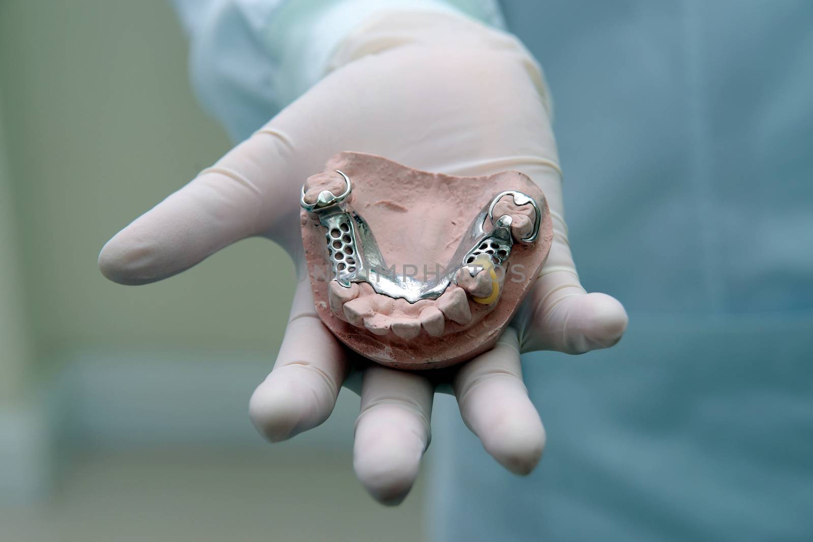 Dentistry show denture in hand.