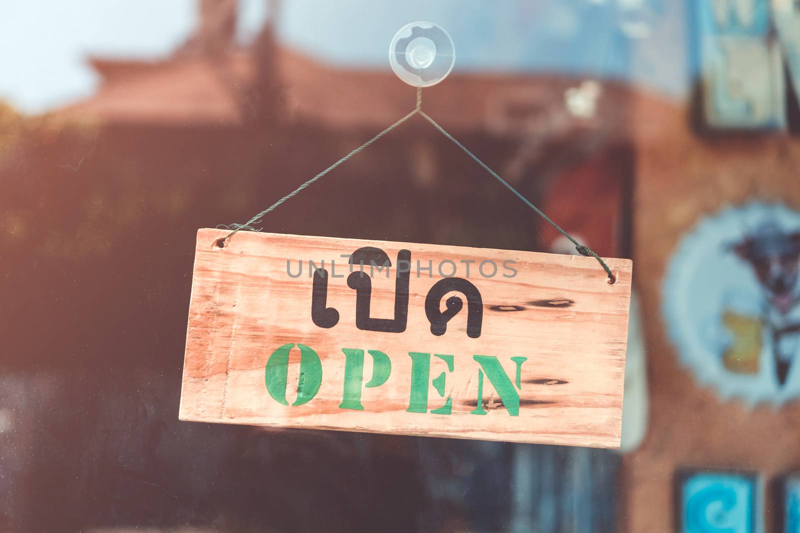 A business sign that says open on cafe or restaurant hang on door at entrance. by Suwant
