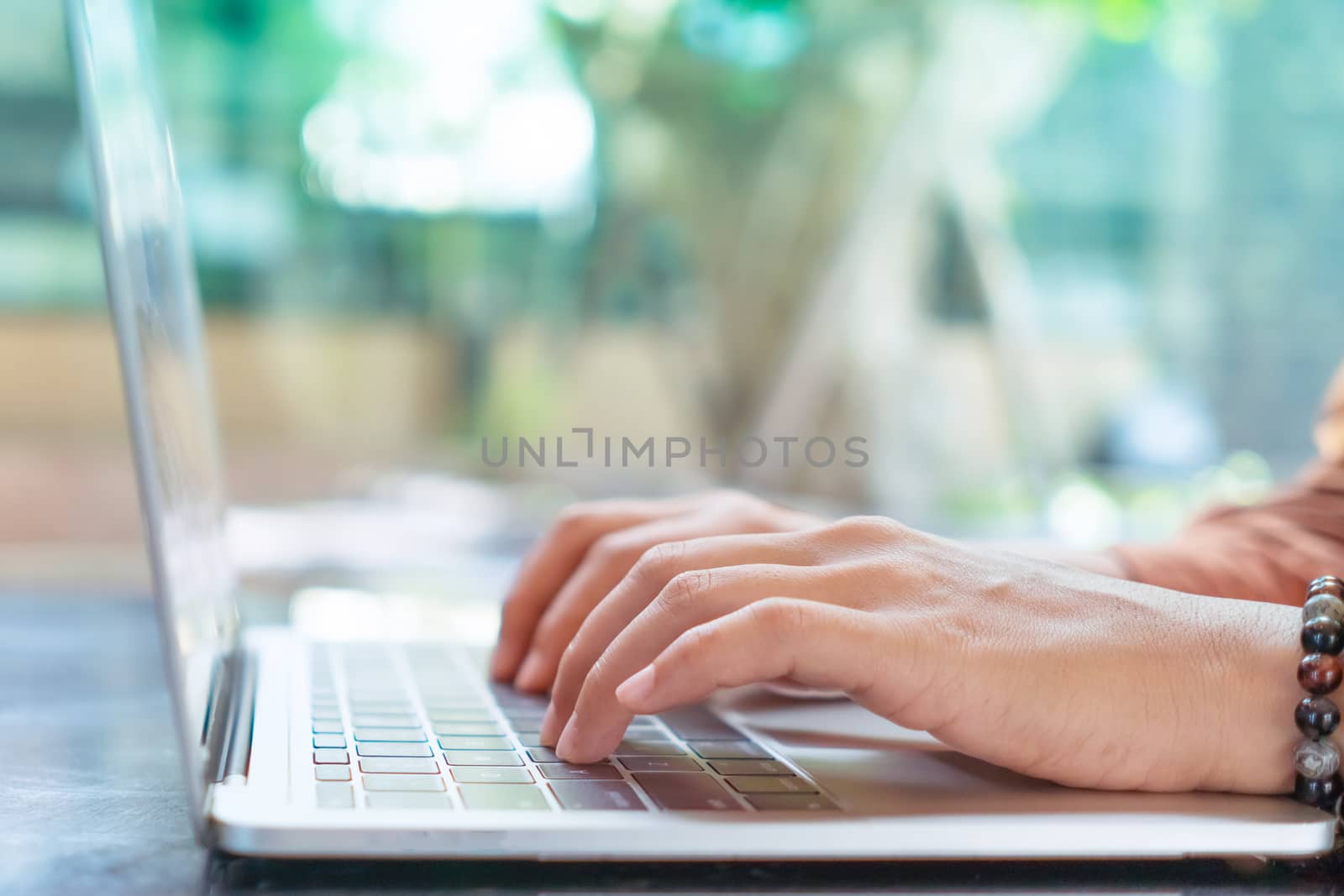 Woman hand using laptop to work study on work desk with clean nature background background. Business, financial, trade stock maket and social network. by Suwant