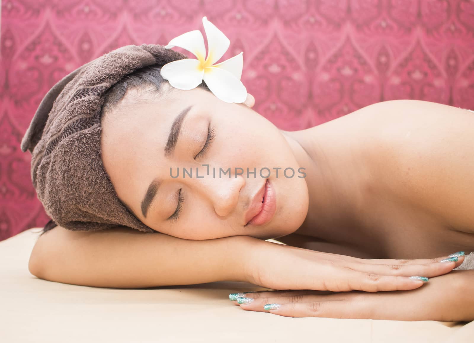 Beautiful asian woman with closed eyes relaxing in spa salon
