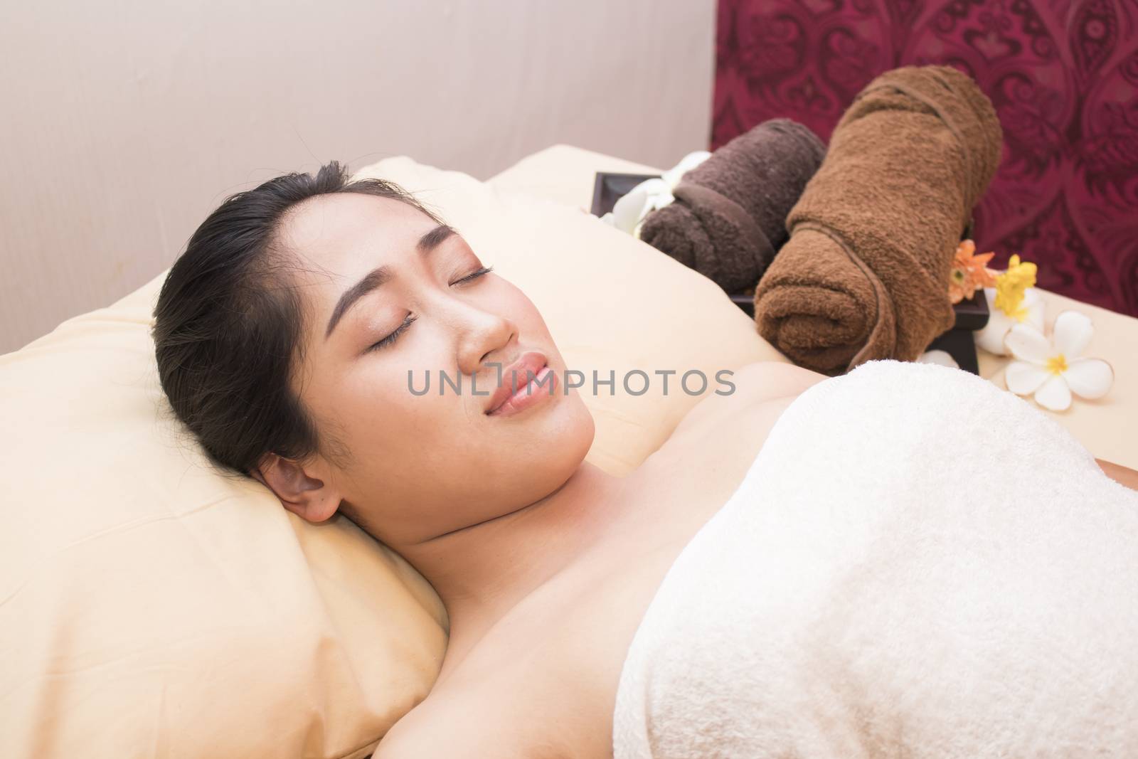picture of asian woman in spa salon lying on the massage desk