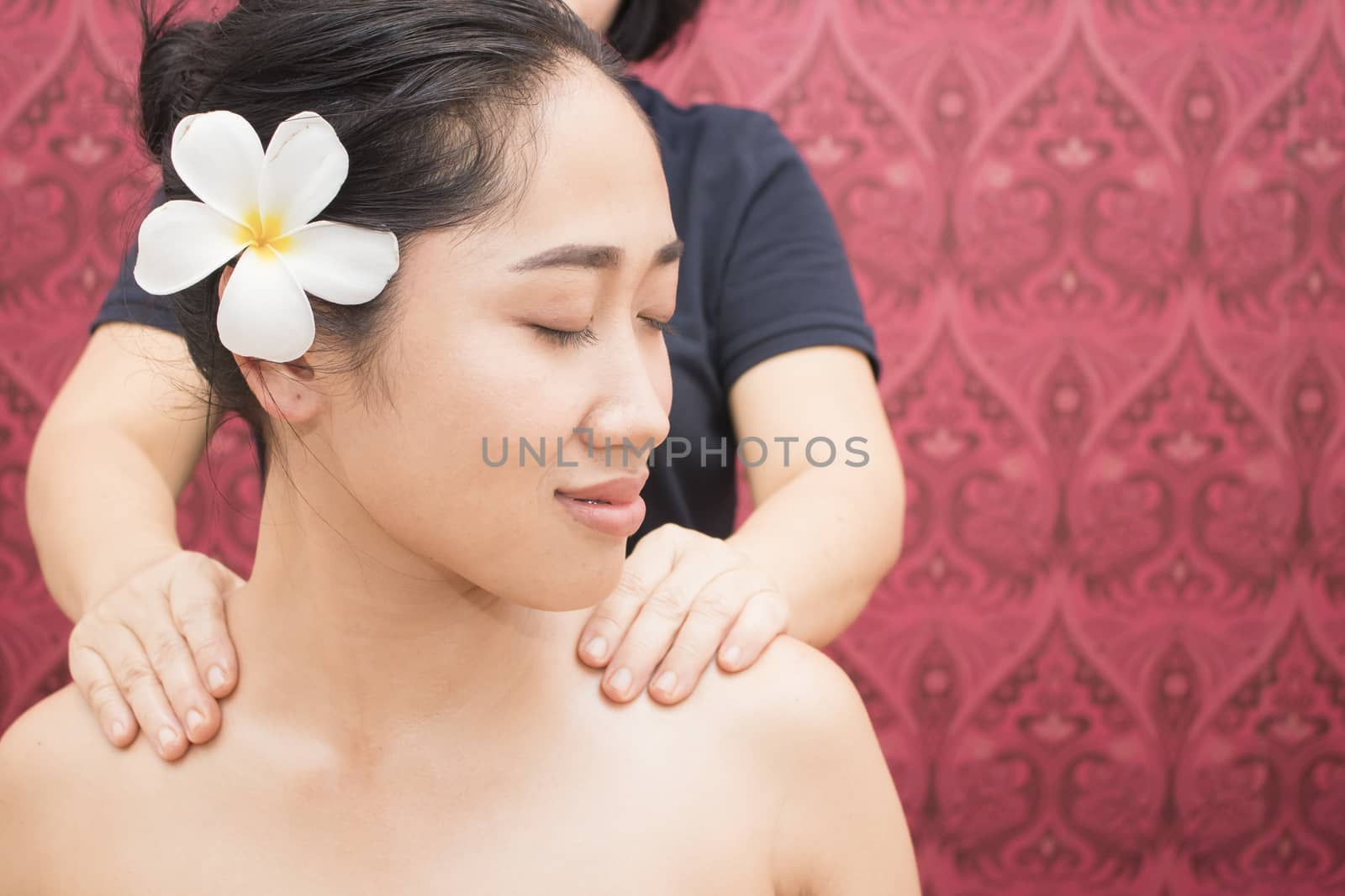 Young woman getting thai massage in spa