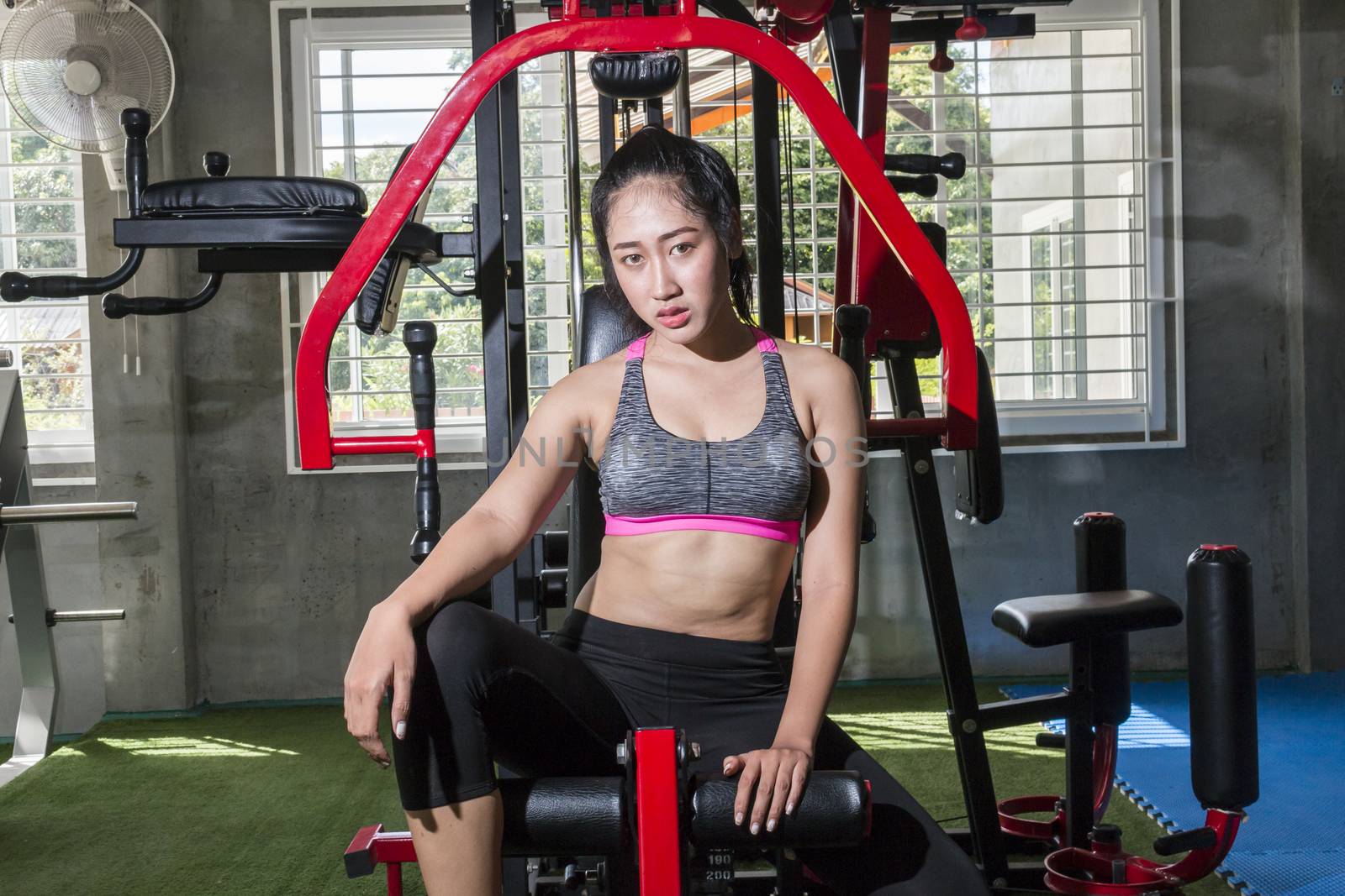 Asian Thai fitness model looking at camera in fitness club