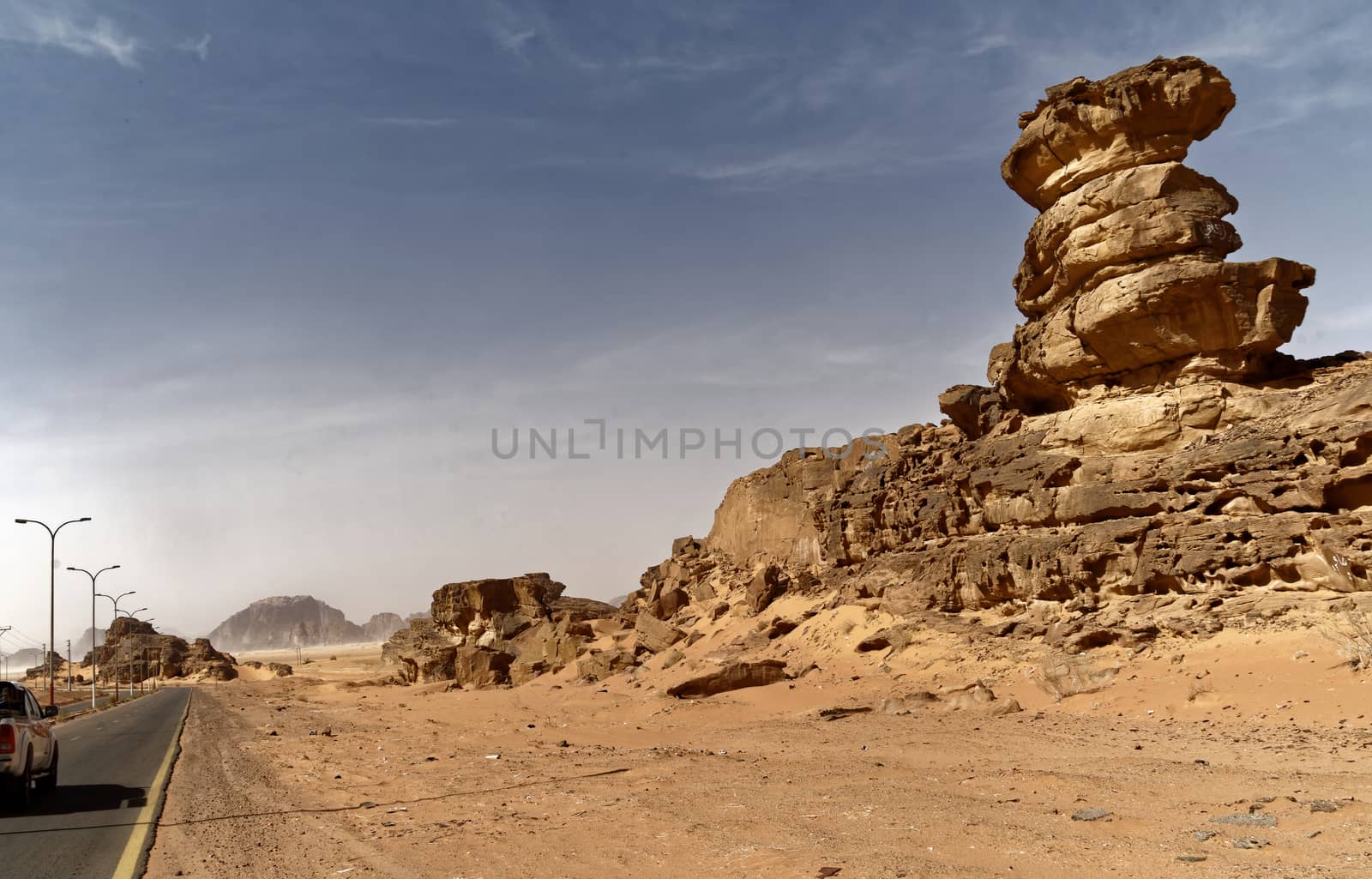 Main road south of the Wadi Rum Nature Reserve, Jordan, with impressive rock formations at the roadside