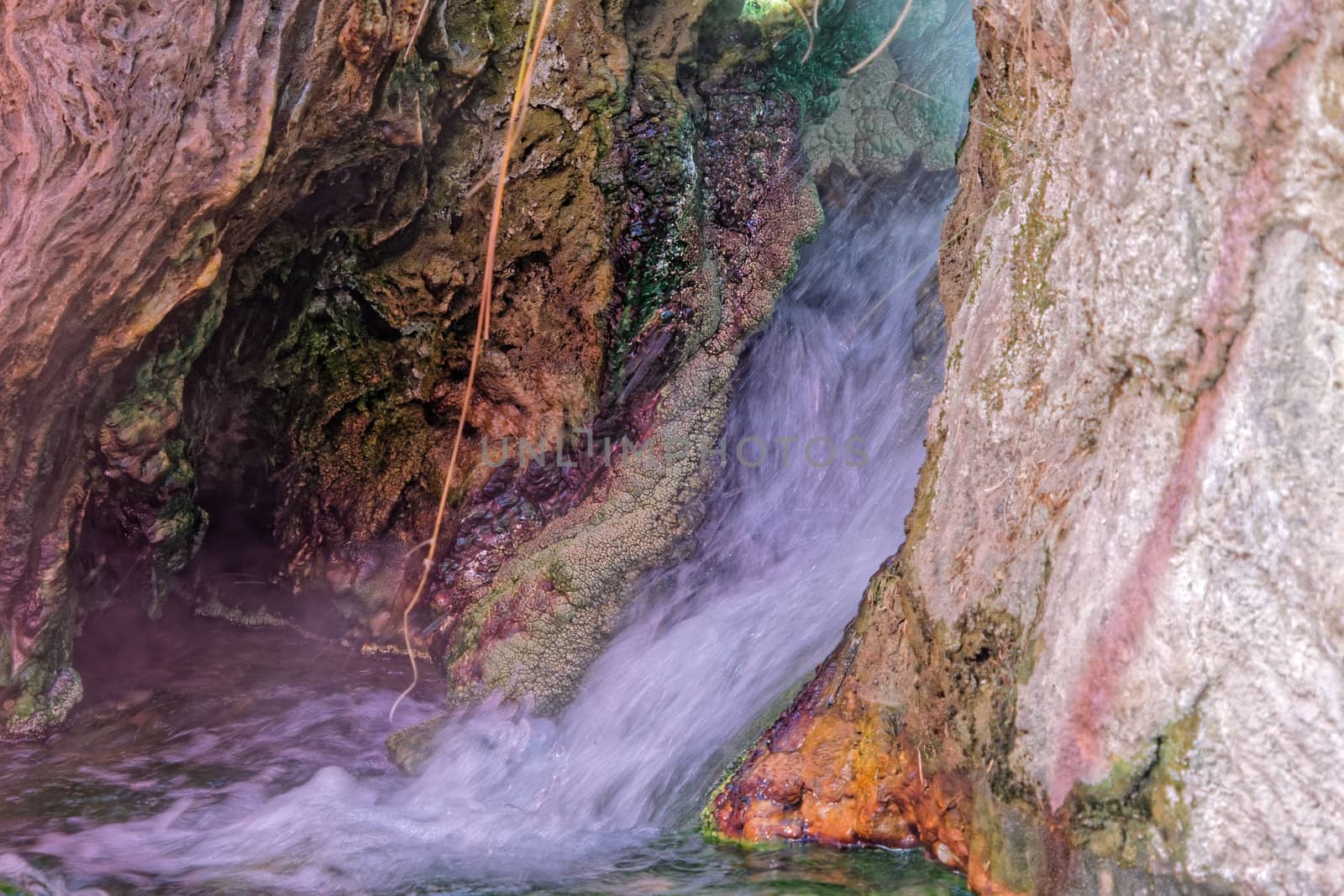 Small waterfall near a hot spring in Main, with colored precipitates of iron, copper, manganese and sulfur compounds by geogif