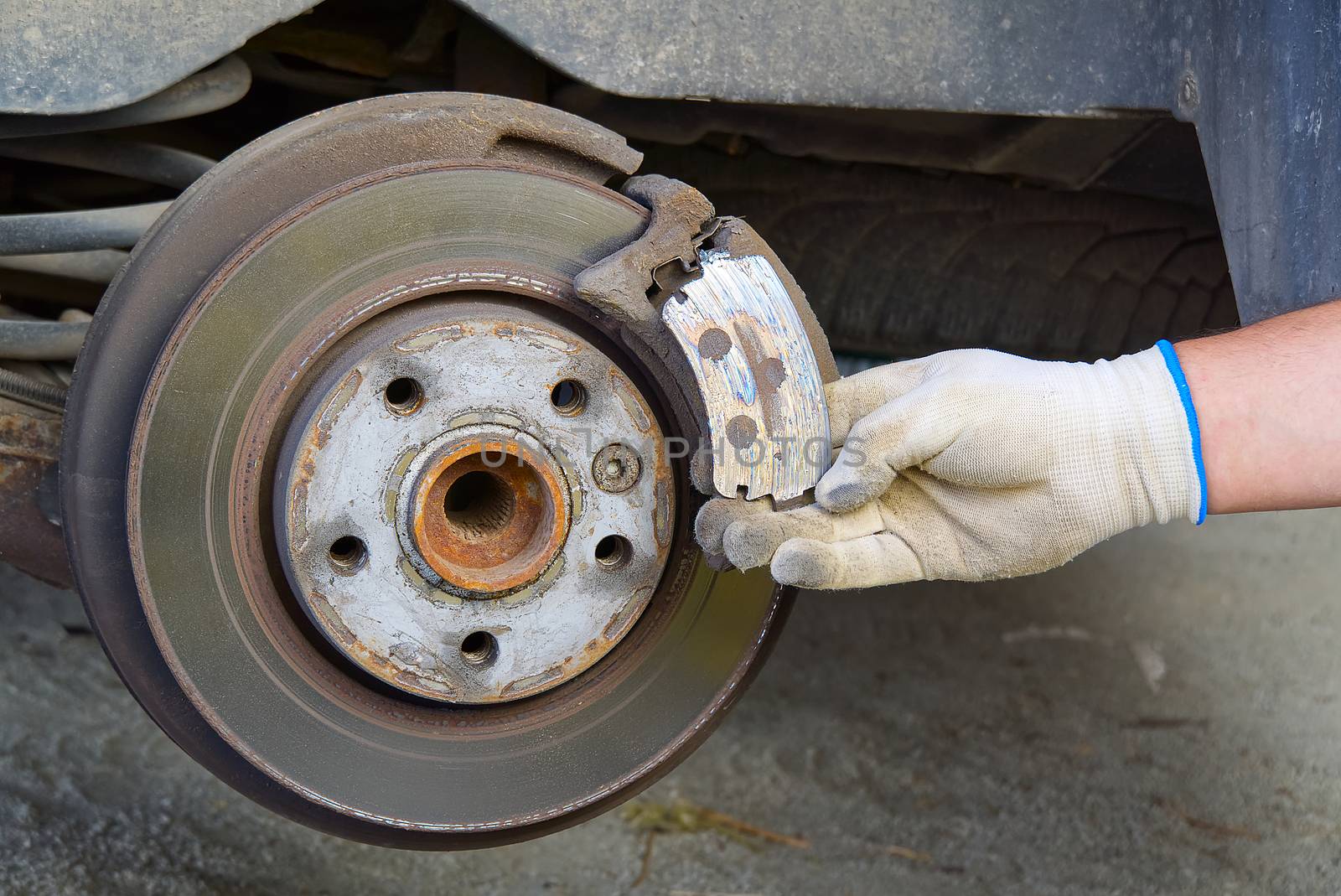 Old and dirty rear dump break of the vehicle for repair. Brakes on a car with removed wheel. Detail image of cars break assembly before repair