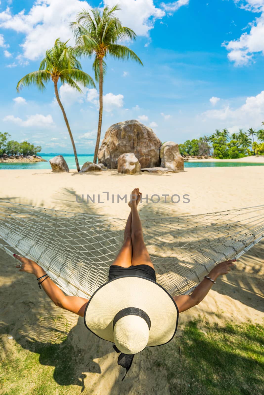 Woman relaxing at the beach on a hammock