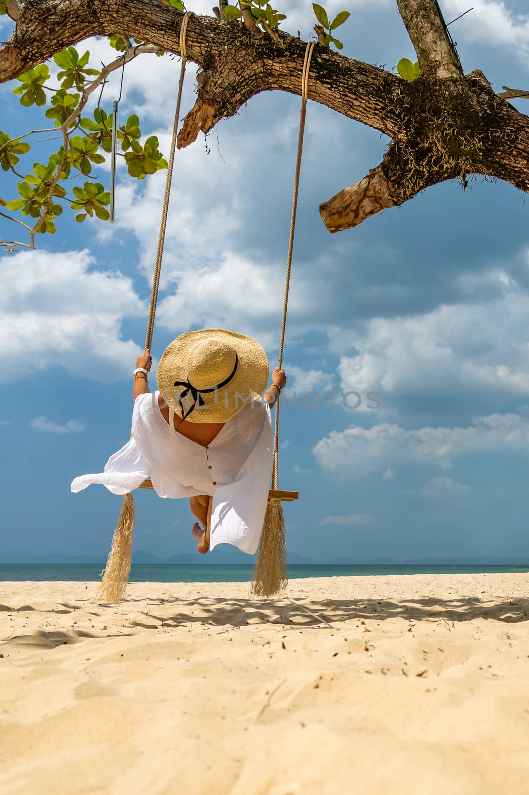 Beautiful Woman on  a swing at the beach in Thailand