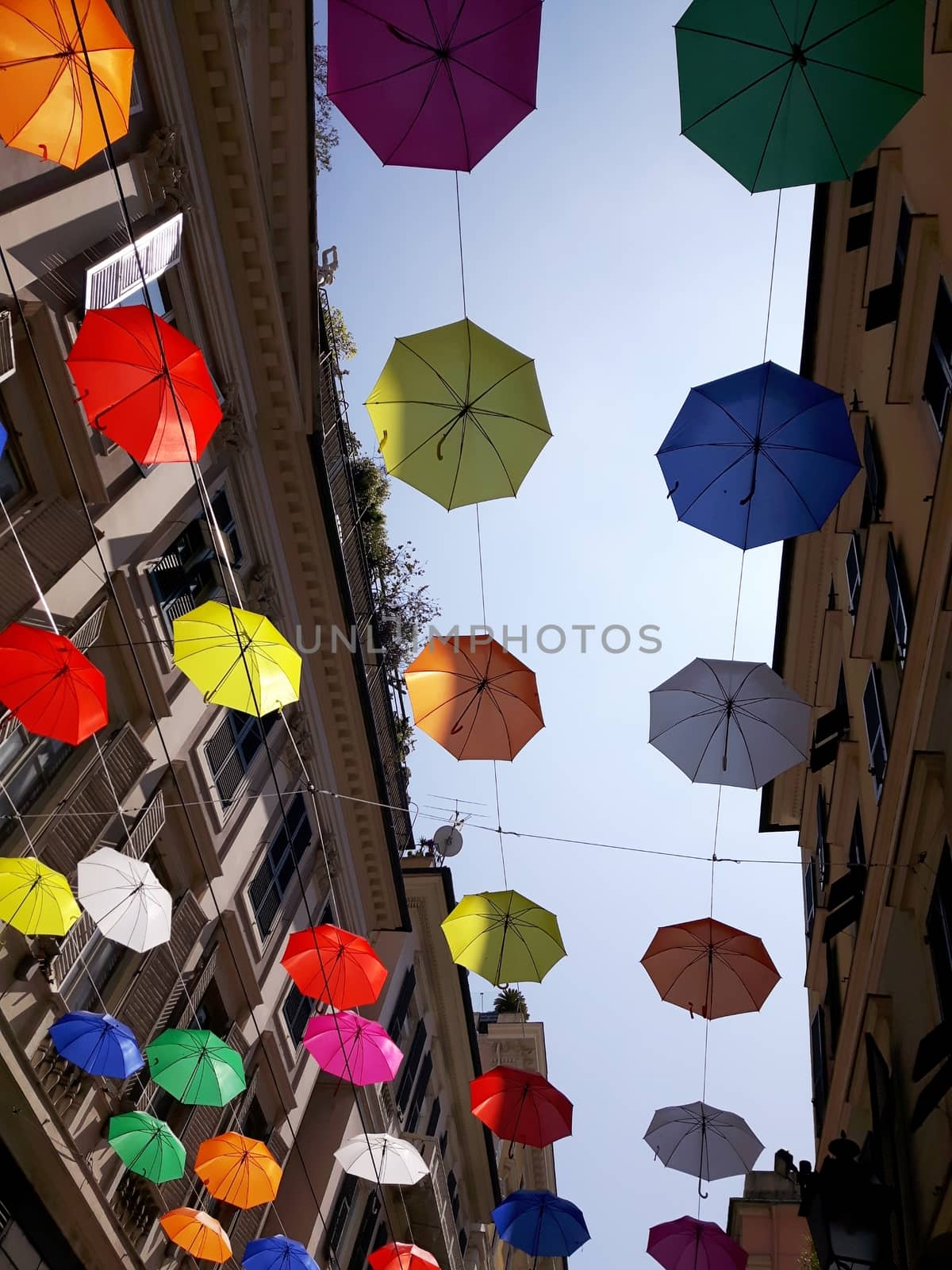 Genova, Italy - 06/01/2020: Bright abstract background of jumble of rainbow colored umbrellas over the city celebrating gay pride