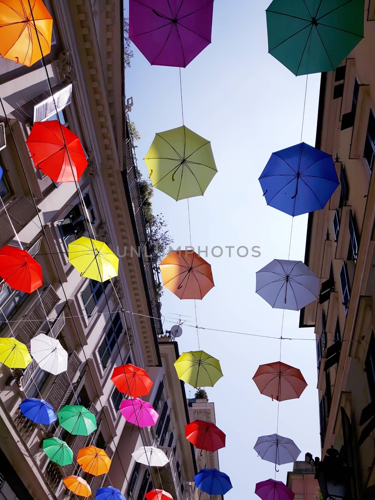 Genova, Italy - 06/01/2020: Bright abstract background of jumble of rainbow colored umbrellas over the city celebrating gay pride