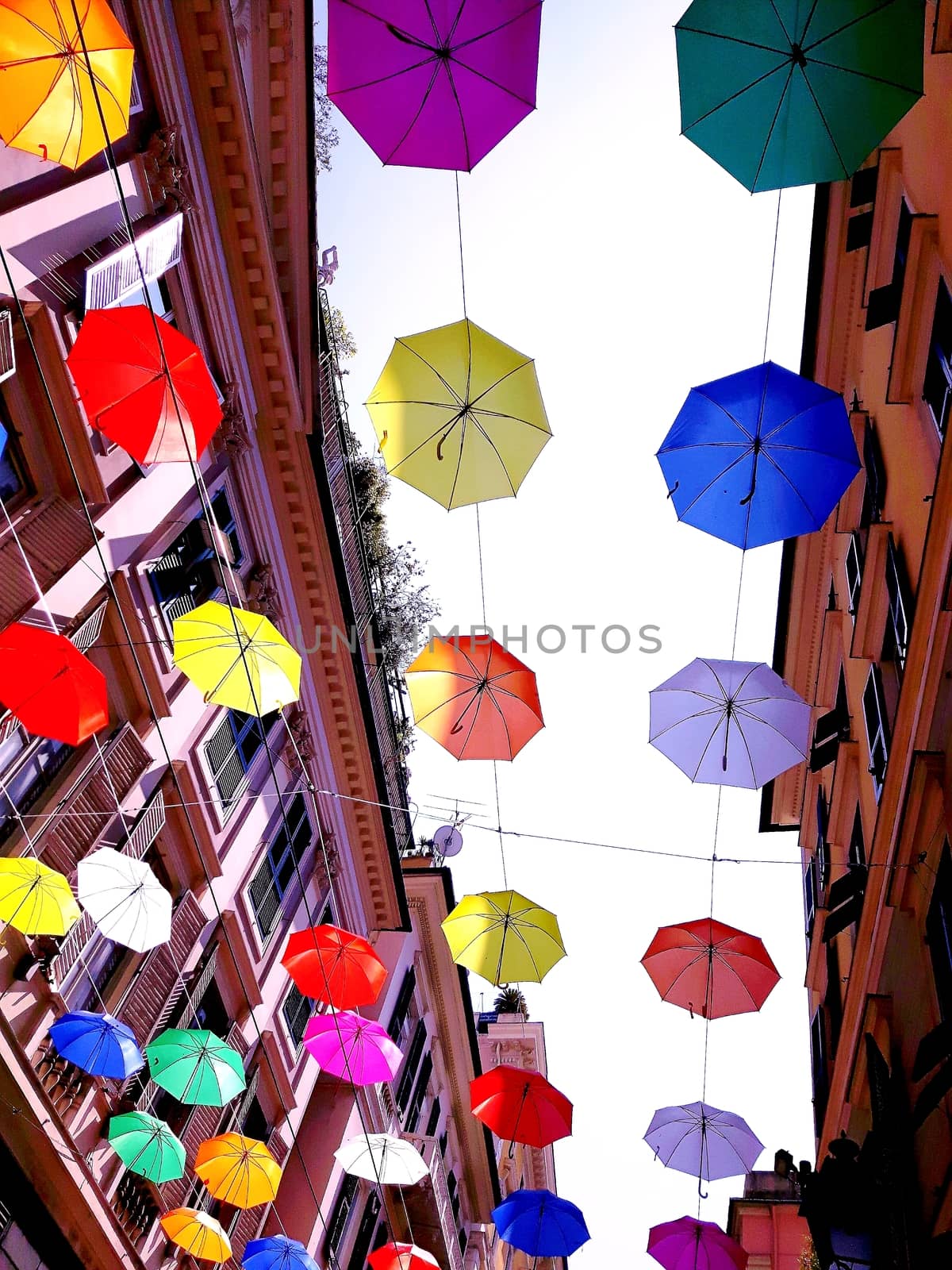 Genova, Italy - 06/01/2020: Bright abstract background of jumble of rainbow colored umbrellas over the city celebrating gay pride