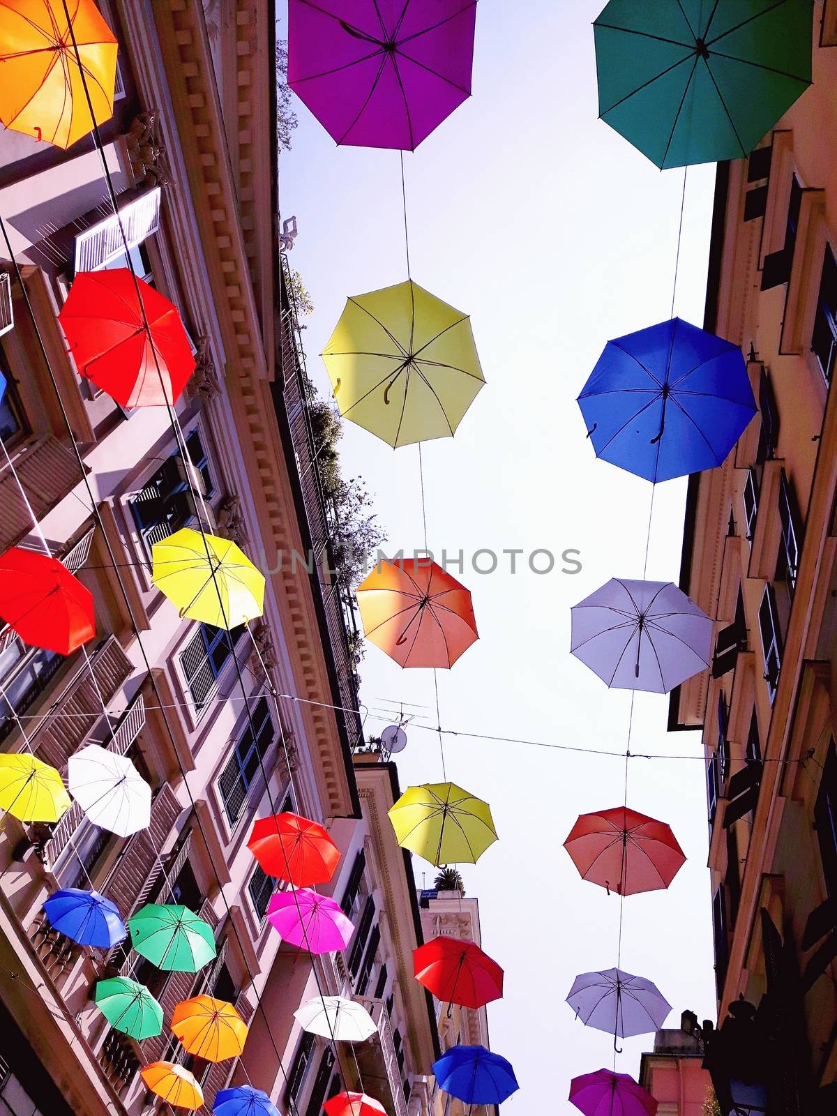 Genova, Italy - 06/01/2020: Bright abstract background of jumble of rainbow colored umbrellas over the city celebrating gay pride