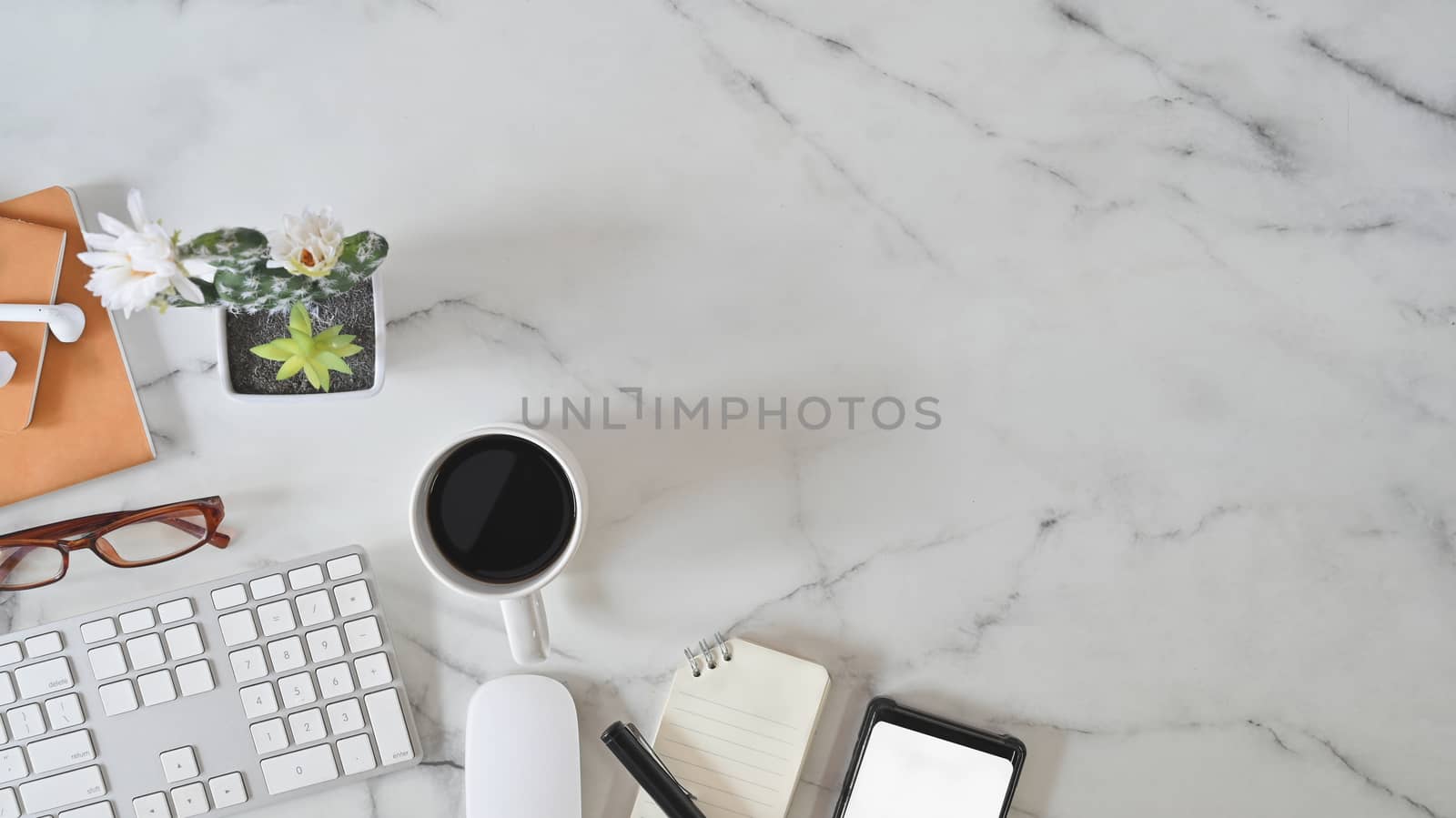 Office desk marble table with computer keyboard, notebook paper, pen and coffee cup. Above shot table.